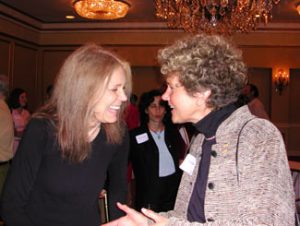 Gloria Steinem shaking hands with Margie Adam