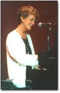 Margie Adam playing the piano.